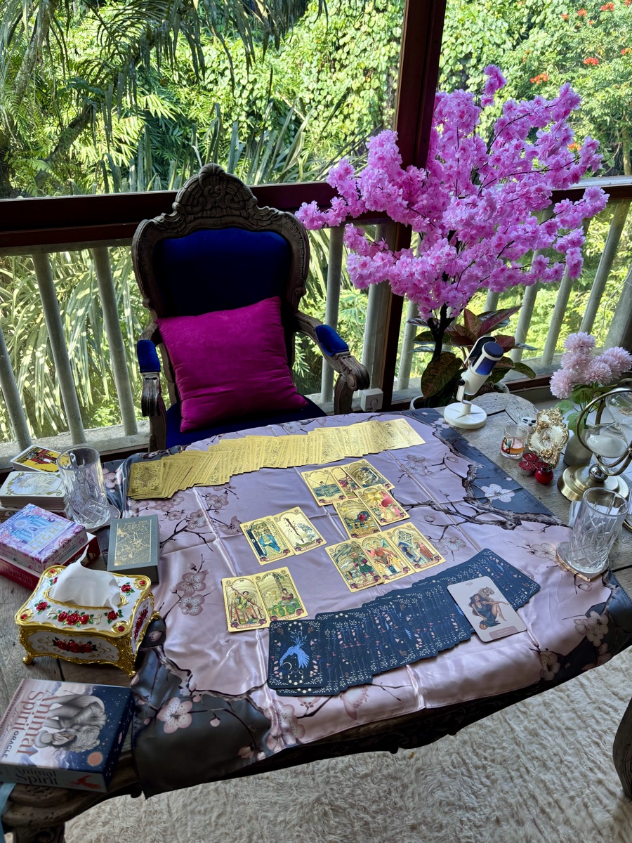 A tarot spread laid out beneath pink blossom