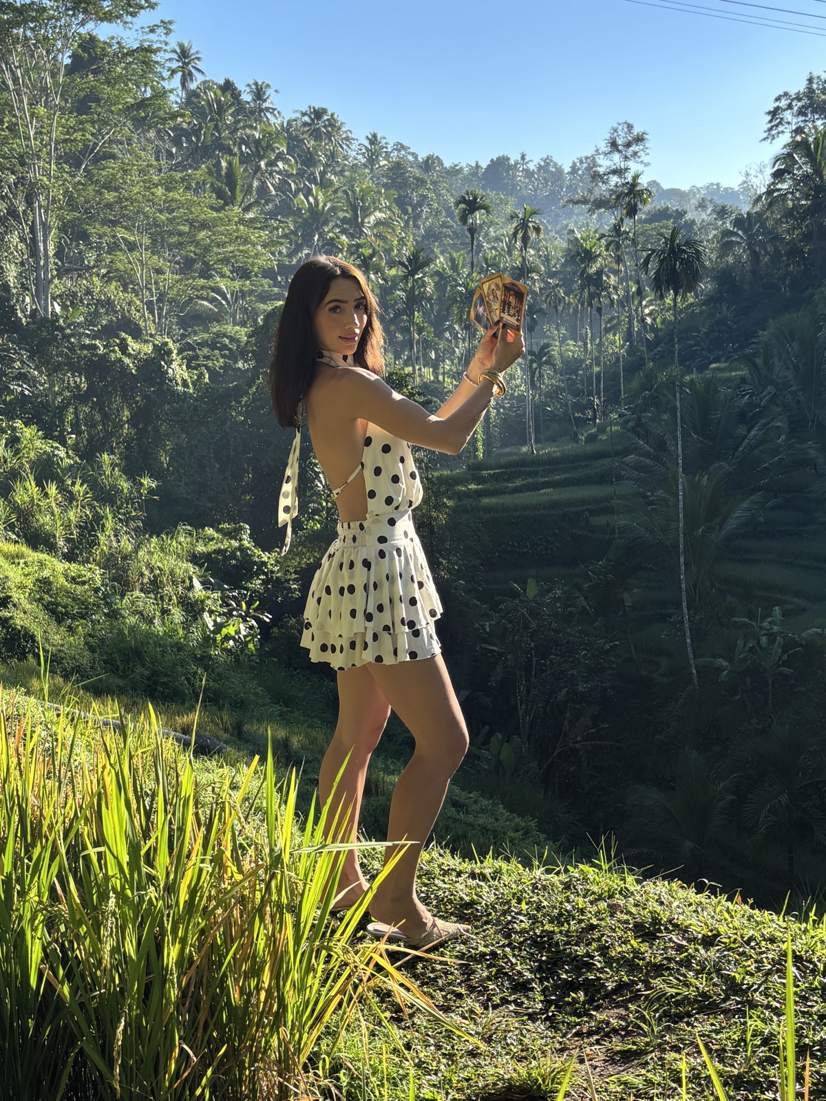 MAÏA holding tarot cards in the Ubud rice terraces